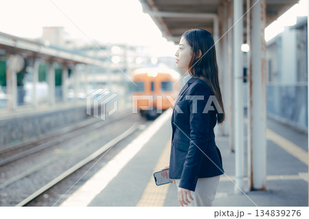 駅のホームでスマホを手に電車を待つ日本人女子大学生 駅のホームでスマホを手に電車を待つ日本人女子大学生 134839276