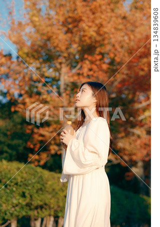 秋の公園で紅茶を飲む日本人女性 134839608