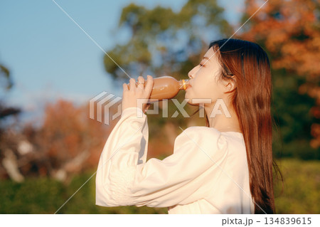 秋の公園で紅茶を飲む日本人女性 秋の公園で紅茶を飲む日本人女性 134839615