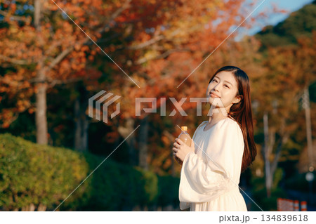 秋の公園で紅茶を飲む日本人女性 134839618
