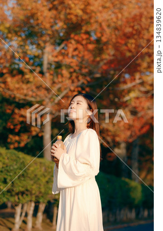 秋の公園で紅茶を飲む日本人女性 134839620