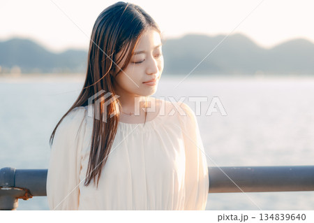海を背景に堤防で佇む日本人女性 134839640