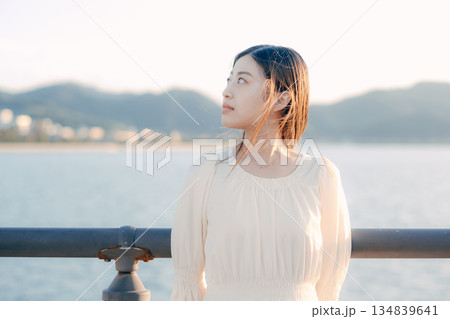 海を背景に堤防で佇む日本人女性 134839641