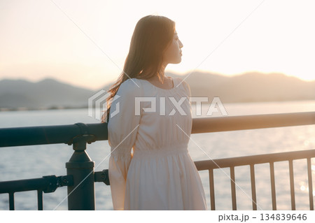 海を背景に堤防で佇む日本人女性 134839646