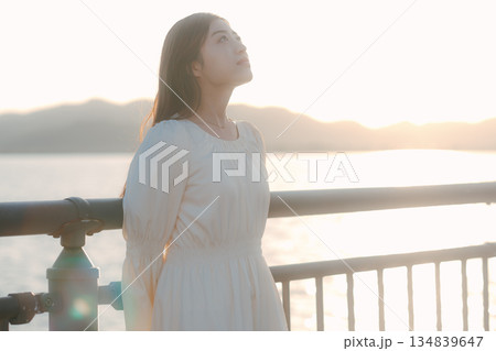 海を背景に堤防で佇む日本人女性 134839647