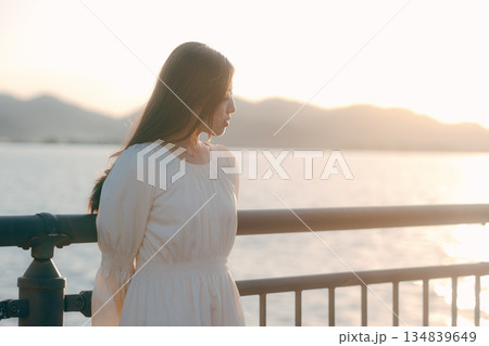 海を背景に堤防で佇む日本人女性 134839649