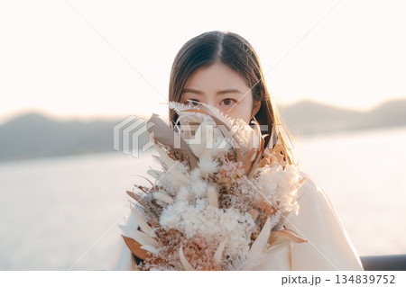 海を背景にドライフラワーを持って佇む日本人女性 134839752