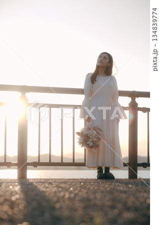 海を背景にドライフラワーを持って佇む日本人女性 海を背景にドライフラワーを持って佇む日本人女性 134839774