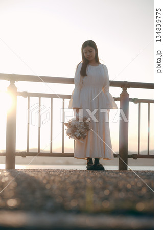 海を背景にドライフラワーを持って佇む日本人女性 134839775