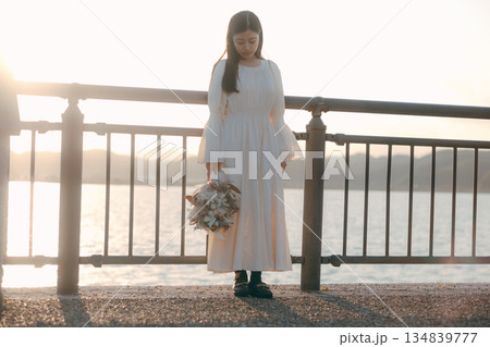 海を背景にドライフラワーを持って佇む日本人女性 134839777