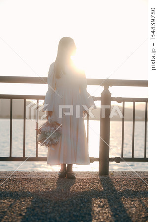 海を背景にドライフラワーを持って佇む日本人女性 134839780