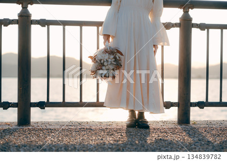海を背景にドライフラワーを持って佇む日本人女性 134839782