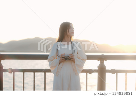 海辺でフィルムカメラを手にする日本人女性 海辺でフィルムカメラを手にする日本人女性 134839851