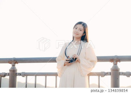 海辺でフィルムカメラを手にする日本人女性 134839854
