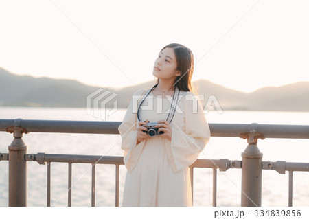 海辺でフィルムカメラを手にする日本人女性 海辺でフィルムカメラを手にする日本人女性 134839856