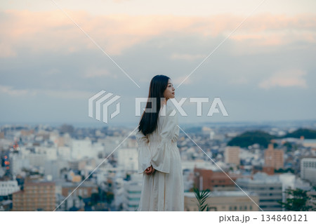 街並みを背景に佇む日本人女性 134840121