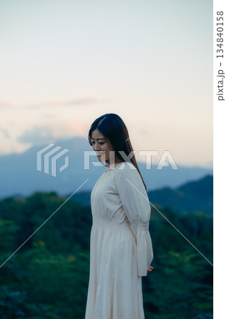 山を背景に佇む日本人女性 山を背景に佇む日本人女性 134840158