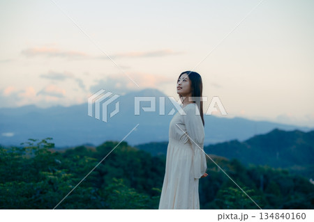 山を背景に佇む日本人女性 山を背景に佇む日本人女性 134840160