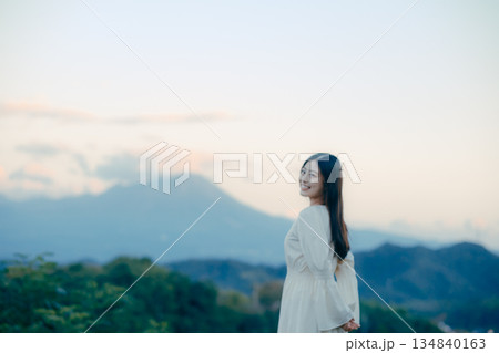 山を背景に佇む日本人女性 134840163