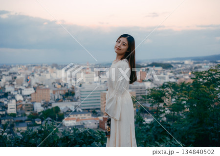 街を見下ろす高台でランタンを持つ女性 134840502