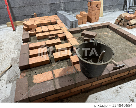 Fresh brickwork of a stove and bench. Smoke channels of the bench laid with brick. Fresh brickwork of a stove and bench. Smoke channels of the bench laid with brick. 134840684