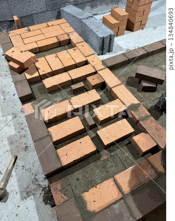 Fresh brickwork of a stove bench. Smoke channels laid with brick. 134840693