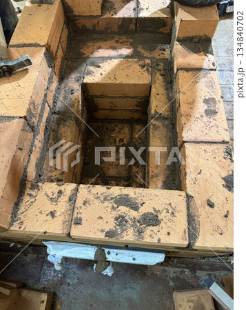 Fresh brickwork of the ash pit and firebox of a heating stove. Fresh brickwork of the ash pit and firebox of a heating stove. 134840702