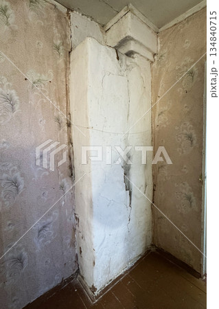 Old heating stove whitewashed with lime. The back side. Cracks and soot marks. 134840715