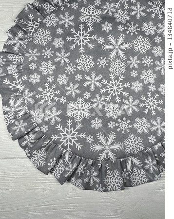 Table setting. Tableware napkin. Round with ruffles. On white boards. Winter theme, snowflake print. Shot from above. 134840718