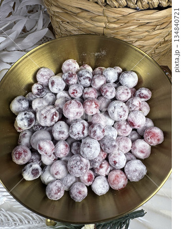 Cranberries in sugar. In a golden cup. Shot from above. Close-up. Cranberries in sugar. In a golden cup. Shot from above. Close-up. 134840721