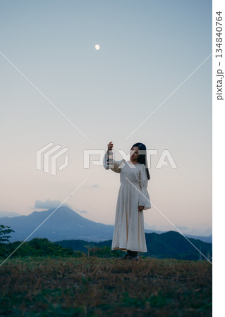 山の夕暮れにランタンを持って佇む女性 山の夕暮れにランタンを持って佇む女性 134840764