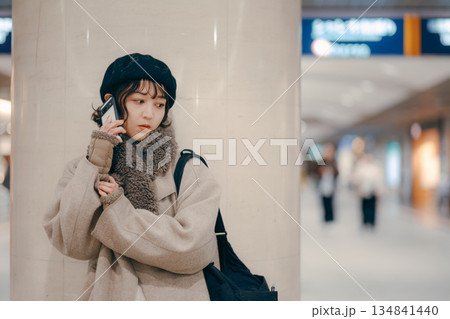 待ち合わせをしながらスマートフォンを使う30代女性 134841440