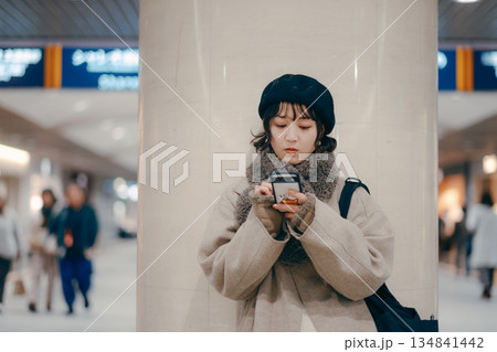 待ち合わせをしながらスマートフォンを使う30代女性 134841442