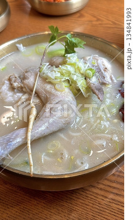 Samgyetang, a hearty Korean ginseng chicken soup, featuring a whole young chicken stuffed with rice, garlic, jujube, and herbs. A nourishing dish perfect for health and comfort. 134841993