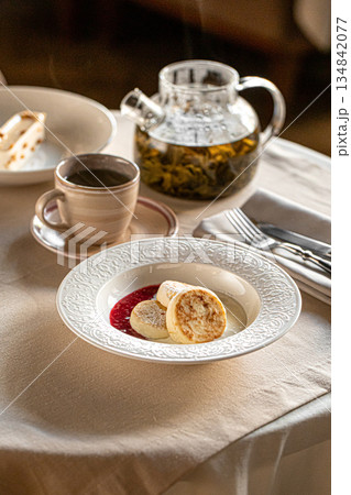 Cheese pancakes with berry sauce and tea Cheese pancakes with berry sauce and tea 134842077
