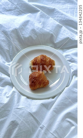 A croissant is a classic French pastry known for its buttery, flaky layers and golden crust. Often enjoyed plain or filled with chocolate, almond, or ham and cheese, it’s a perfect for breakfast 134842205