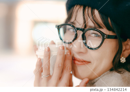 コーヒーカップを手に微笑む30代女性のポートレート 134842214