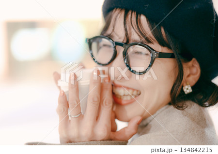 コーヒーカップを手に微笑む30代女性のポートレート 134842215