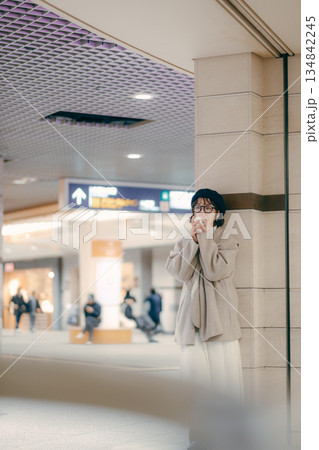 待ち合わせ中にコーヒーを飲む30代女性の全身ポートレート 待ち合わせ中にコーヒーを飲む30代女性の全身ポートレート 134842245