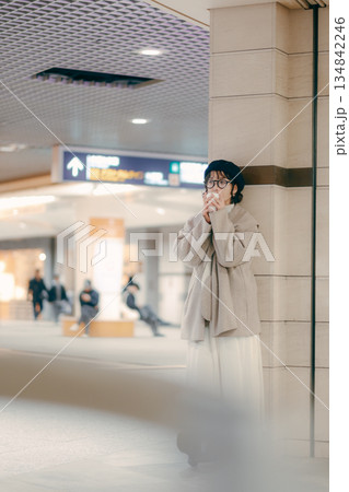 待ち合わせ中にコーヒーを飲む30代女性の全身ポートレート 134842246