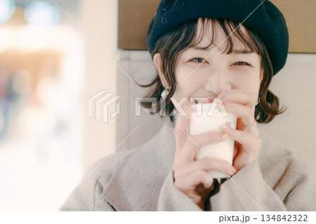 コーヒーを飲みながら待つ30代女性のアップポートレート 134842322