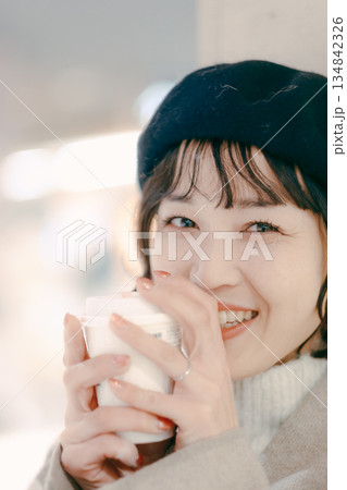 コーヒーを飲みながら待つ30代女性のアップポートレート コーヒーを飲みながら待つ30代女性のアップポートレート 134842326