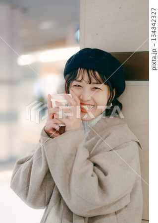 コーヒーを飲みながら待つ30代女性のアップポートレート コーヒーを飲みながら待つ30代女性のアップポートレート 134842327
