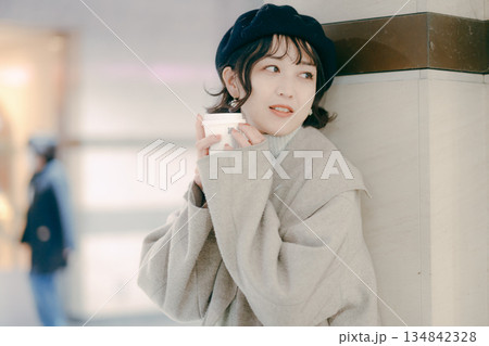 コーヒーを飲みながら待つ30代女性のアップポートレート 134842328