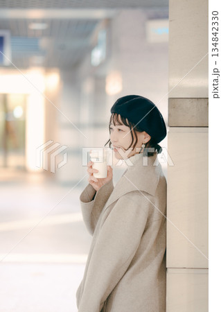 コーヒーを飲みながら待つ30代女性のアップポートレート 134842330