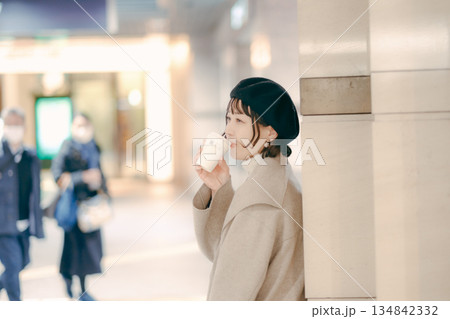 コーヒーを飲みながら待つ30代女性のアップポートレート 134842332