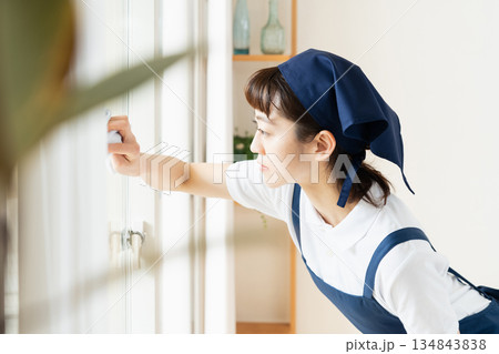 窓拭きをする家事代行の女性 窓拭きをする家事代行の女性 134843838