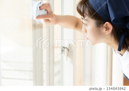 窓拭きをする家事代行の女性 134843842