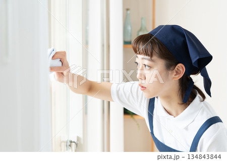 窓拭きをする家事代行の女性 窓拭きをする家事代行の女性 134843844