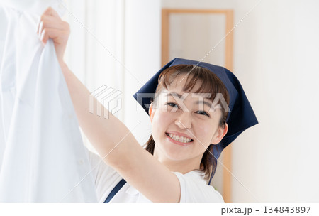 洗濯物を干す家事代行の女性 洗濯物を干す家事代行の女性 134843897